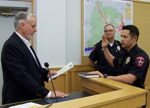 Officer Gabriel Galindo is sworn in by Smithfield Mayor John Lampe as Police Chief Michael Scott looks on. WTSB Photo
