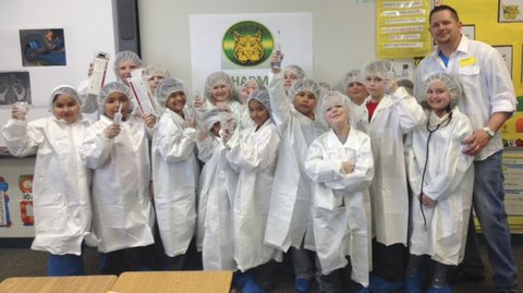 Caption: Jason Atkinson from Mallinckrodt Pharmaceuticals visits Micro-Pine Level Elementary School. Front row: Zarela Guzman-Reyes, Geisel Cerventes- Gutierrez, Edgar Franco, Israel Gutierrez-Vargas, Damaris Avila-Perez, Josh Dubon, Max Soronen, Jaylon Gray, and Lani Atkinson. Second row: Paige Witman, Treyson Grams, Ashley Hendrix, Carlie Aycock, Aaron Taylor, and Mr. Jason Atkinson.