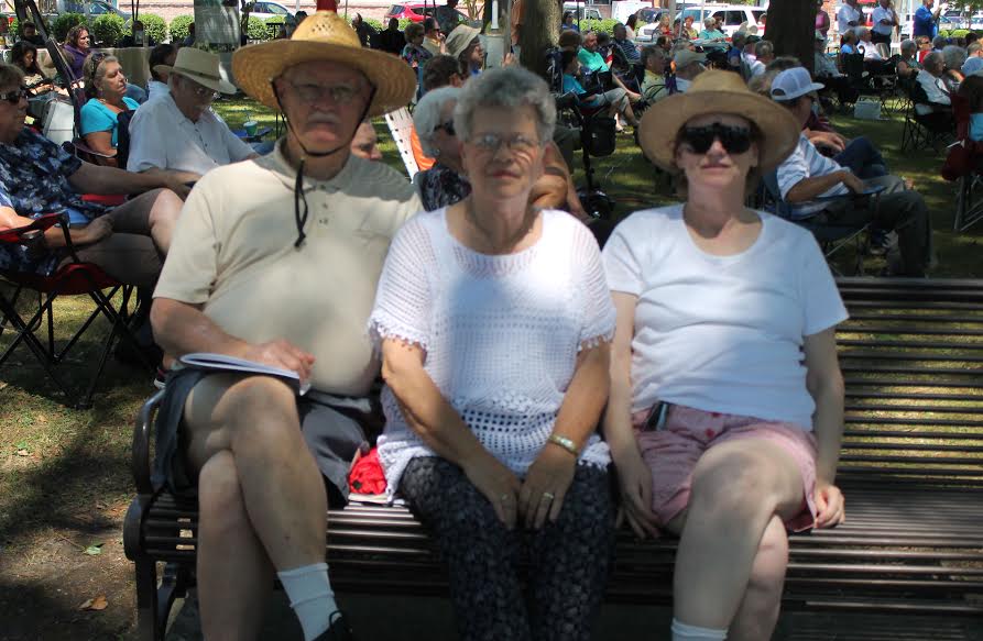 From left to right, James Jernigan, Louise Bradford and Janice Spruill grab a shady spot in the Singing Grove to enjoy the gospel music.