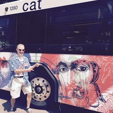 West Johnston High Art Teacher Frank Kreacic stands behind the Raleigh bus which features his art.