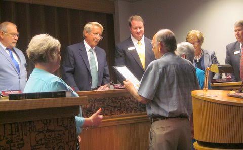 Ricky Brady (center holding plaque) and his wife Brenda (right) are honored by Johnston County Commissioners for creating an endowment scholarship for Johnston County employees and their families.