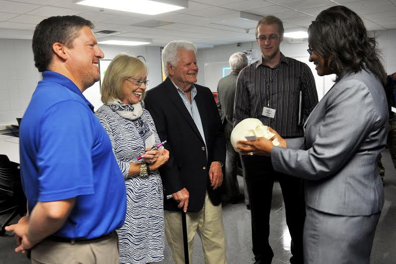 Dr. Katherine Stevenson-Chavis, lead engineering instructor, shows Lyn Austin, JCC trustee chair, and community members a skull prototype created by the program's 3D printer.