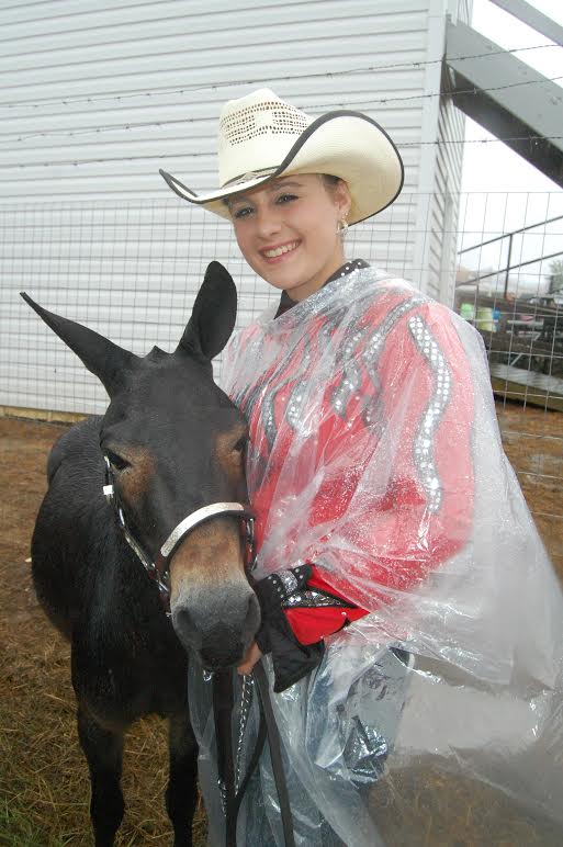 The 66th annual Mule Days celebration saw some wet weather during the weekend. There were just as many rain slickers as cowboy hats, but the festivities stubbornly continued on. In the photo, Lizzy Scott, 18, of Benson, poses with her miniature mule Snickers outside the Nowell Smith Arena in Benson’s Chamber Park on Friday morning before the mule judging competition. Courtesy The Daily Record