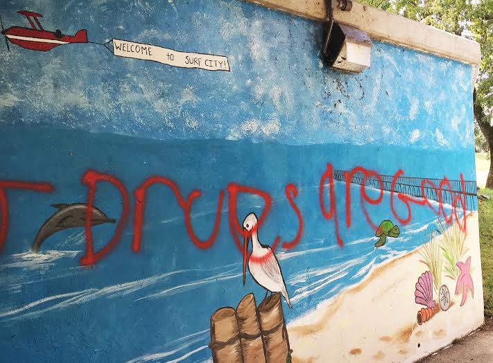 This photo shows graffiti spray painted on the Mountains to Sea Mural on the Neuse River Greenway in Smithfield.