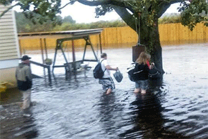 Rescue workers aid a family as flood waters surround their home in Palmico County.