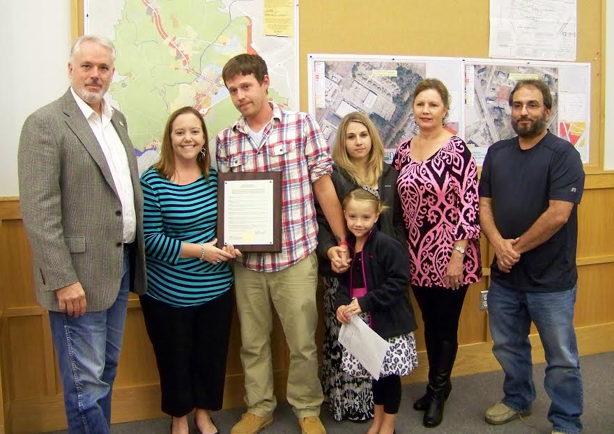 Smithfield Mayor John Lampe (left) presents a proclamation from the Smithfield Town Council to the family of slain Johnston County sheriff’s deputy Clendon Paul West Sr. formally requesting the NC DOT rename the Market Street bridge in his memory. WTSB Photo
