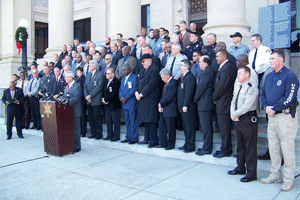 Sheriff’s from more than 20 NC counties including Sheriff Steve Bizzell, Johnston County deputies, US Marshals, NC SBI, NC Probation, and NC Highway Patrol officials participate in a press conference for Operation Home For the Holidays? on the steps of the Johnston County Courthouse on Friday. WTSB Photo