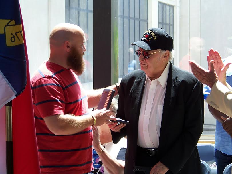 (Right to Left) Edward M. Kirks, one of 4 brothers from Selma to fight in World War II, is surprised by his grandson, Army veteran Travis Kirks, during the Memorial Day Ceremony at the Johnston County Courthouse. Travis drove in from Texas to present his grandfather with 3 World War II medals he should have received in 1945. JoCoReport.com Photo