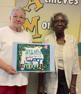Selma Downtown Partnership Member Dina Flowers (left) and Selma Mayor ProTem Jackie Lacey (right) show Tajiya Davis’ winning poster design.